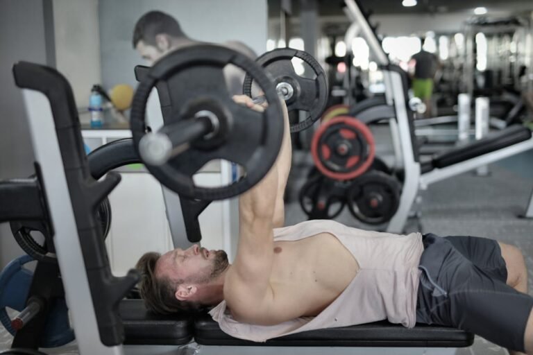 en man som utför bänkpress på gymmet